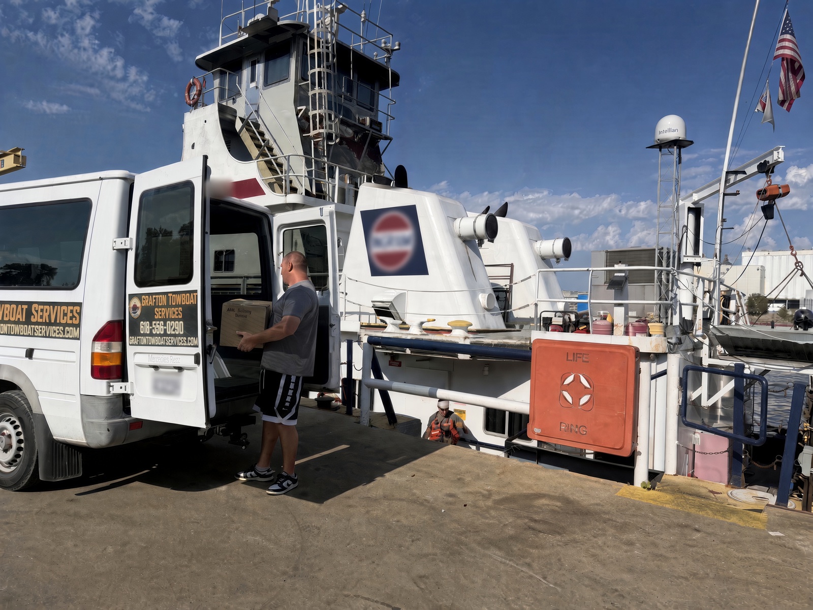Grafton Towboat Services staff loading supplies from the van onto a towboat at the dock
